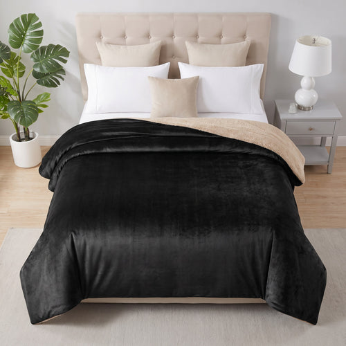 Black and beige reversible crystal velvet blanket on a bed