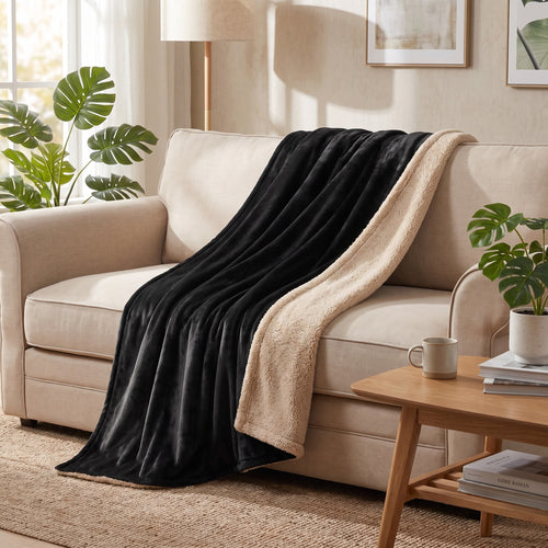 Black and beige reversible blanket styled on a sofa